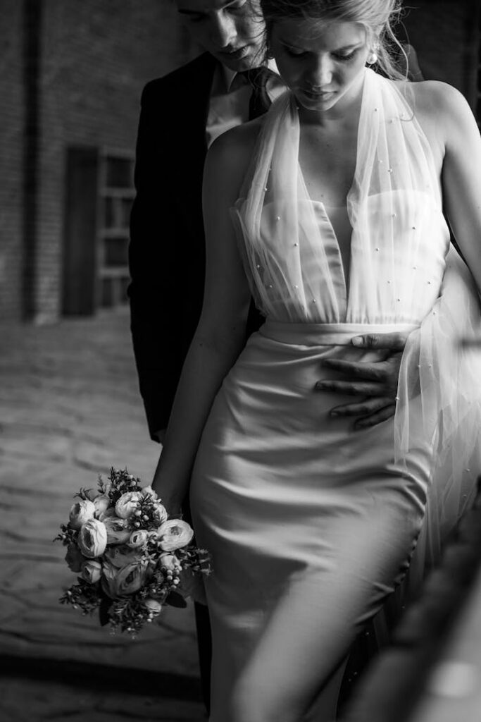 Romantic black and white portrait of a bride and groom embracing on their wedding day.
